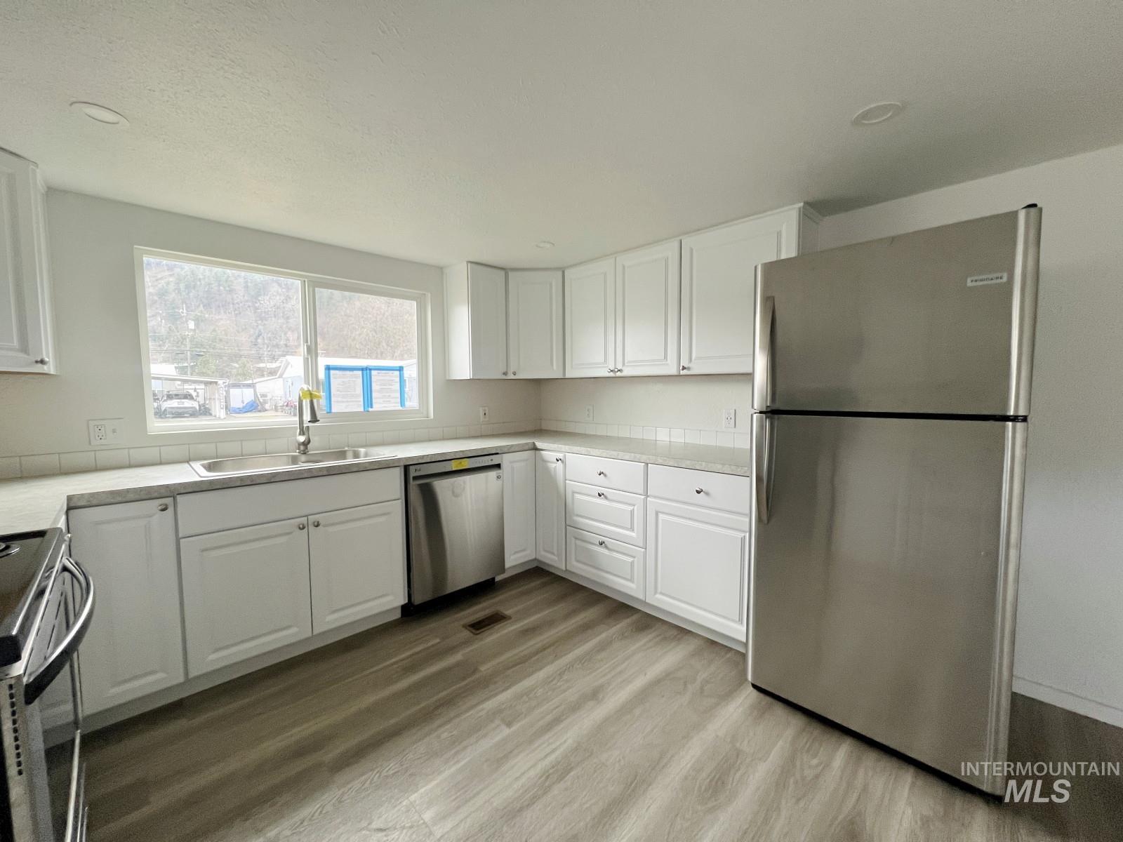 614 Pine Avenue Kooskia, ID 83539 - Photo 10 of 27 Kitchen featuring stainless steel appliances, white cabinets, and light countertops