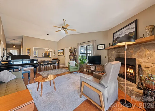 a living room with furniture a flat screen tv and kitchen view