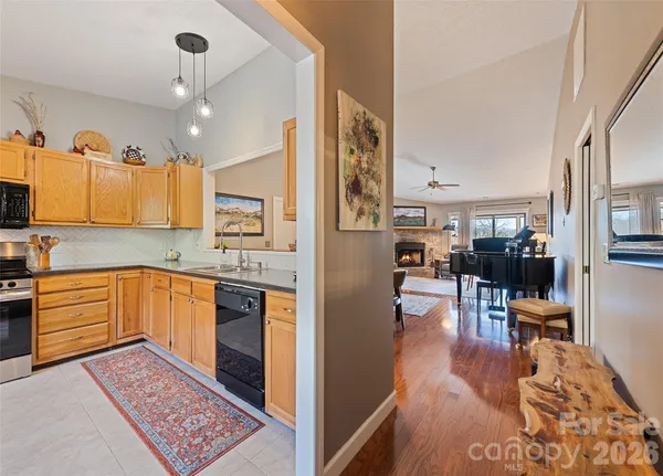 a kitchen with stainless steel appliances granite countertop a refrigerator oven stove a sink dishwasher and wooden cabinets with wooden floor