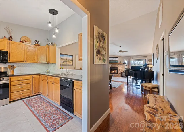 a kitchen with stainless steel appliances granite countertop a refrigerator oven stove a sink dishwasher and wooden cabinets with wooden floor