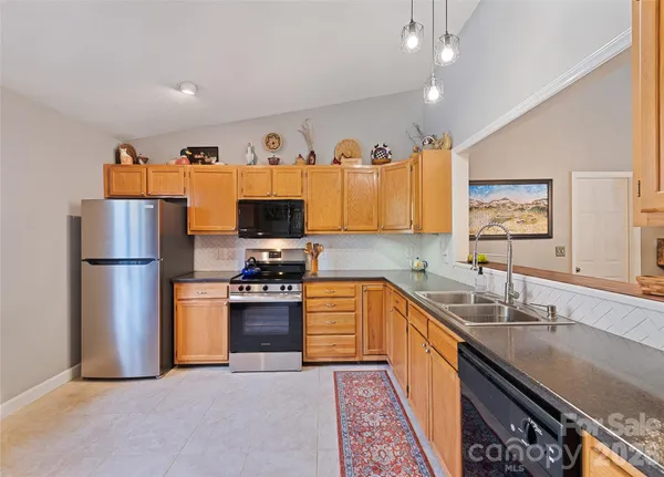 a kitchen with stainless steel appliances granite countertop a refrigerator a sink a stove and island