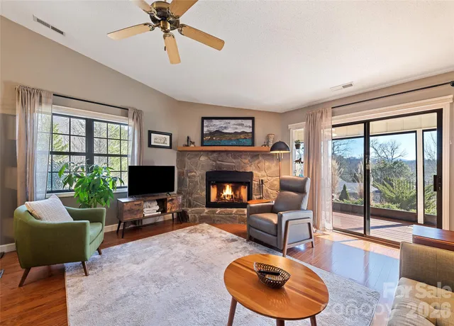 a living room with furniture a fireplace and a large window