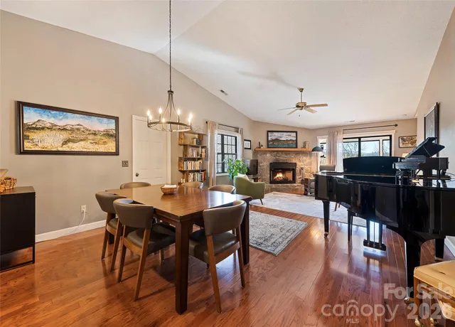 a view of a dining room with furniture a rug and wooden floor