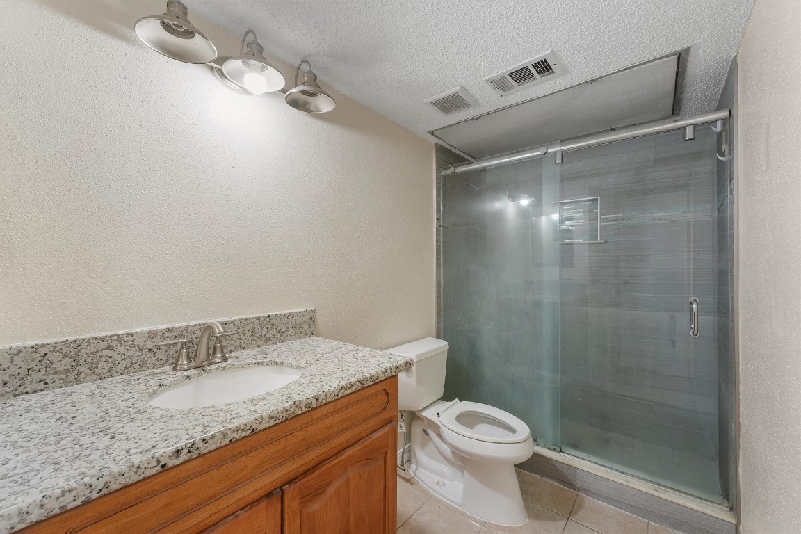 9221 Imogene Street, Unit 9221 Houston, TX 77036 - Photo 13 of 19 a bathroom with a granite countertop sink toilet and shower