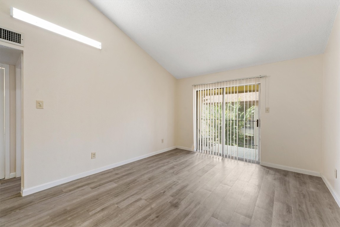 9221 Imogene Street, Unit 9221 Houston, TX 77036 - Photo 8 of 19 an empty room with wooden floor and windows