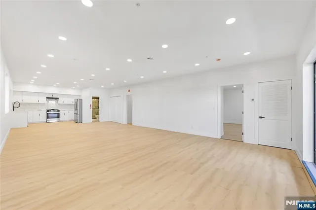 a view of an empty room with a kitchen