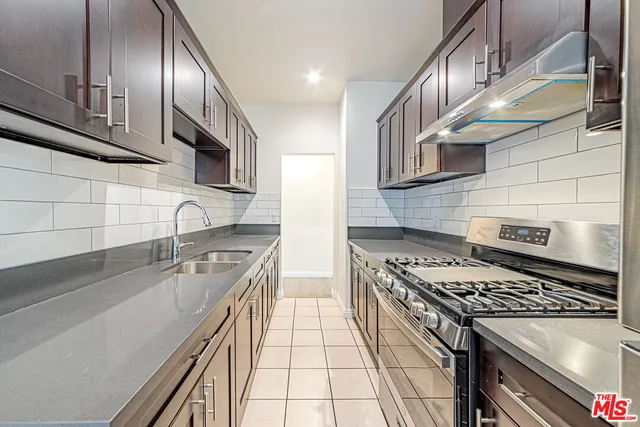 a kitchen with stainless steel appliances granite countertop a sink a stove and cabinets