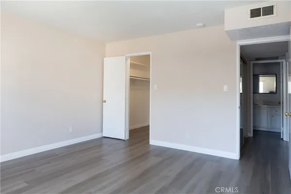 an empty room with wooden floor and closet
