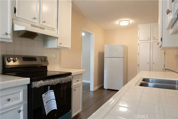 a kitchen with stainless steel appliances granite countertop a refrigerator a stove and a sink