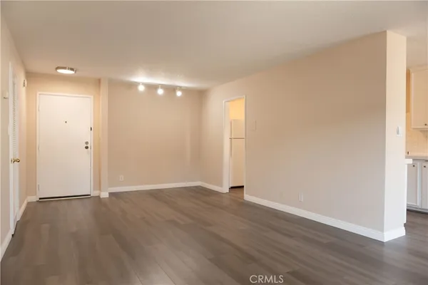 an empty room with wooden floor & window