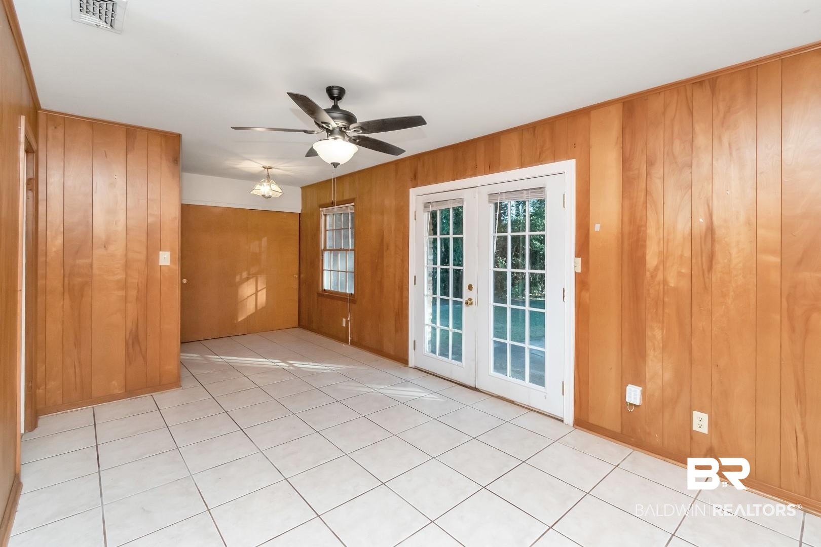 5517 Vanderbilt Drive Mobile, AL 36608 - Photo 11 of 33 Unfurnished room featuring ceiling fan, wooden walls, and french doors