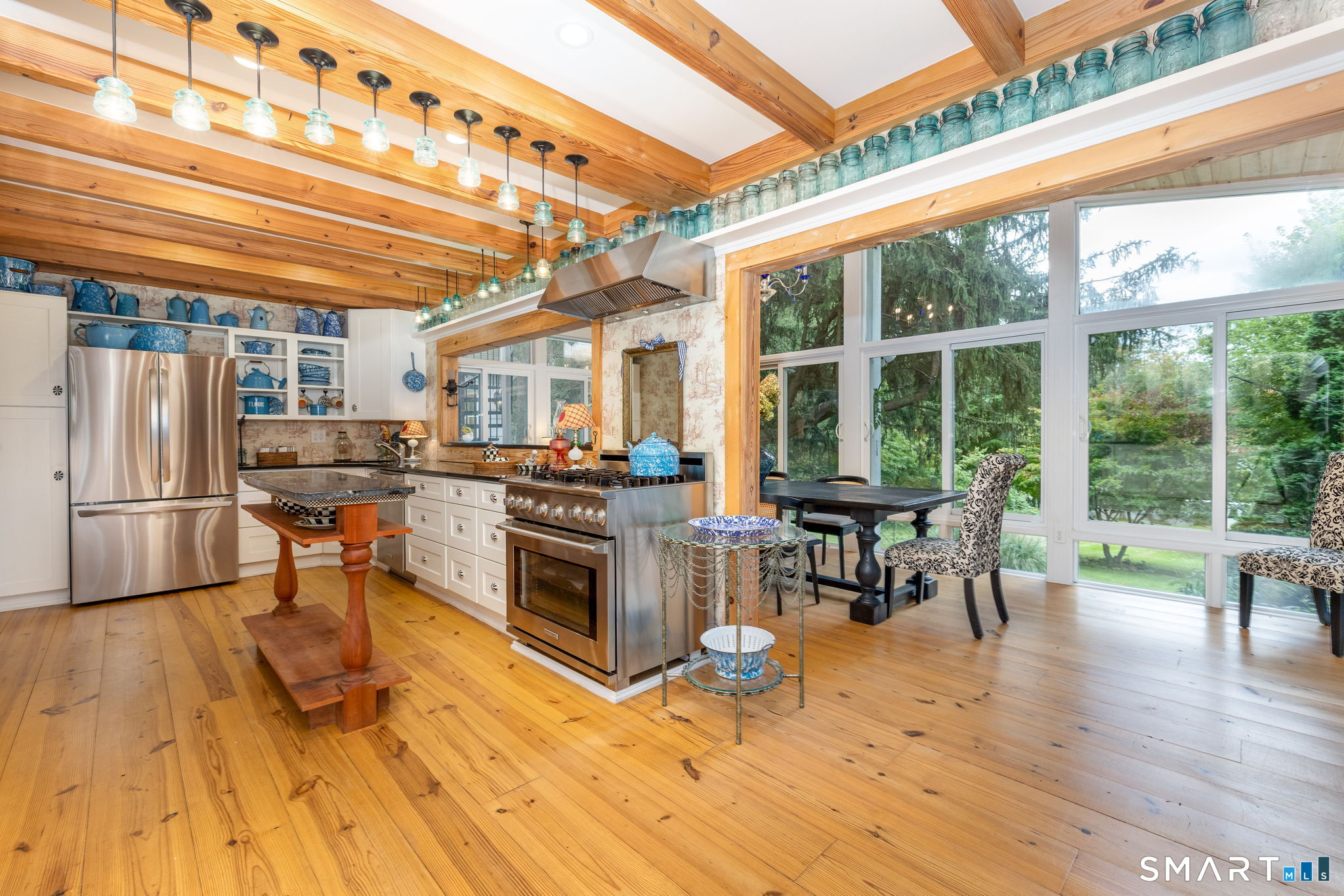 695 Spindle Hill Road Wolcott, CT 06716 - Photo 10 of 40 Main Kitchen & Dining Sunroom: Premium open-concept culinary space styled with white shaker cabinetry, Black Absolute Granite, and MacKenzie-Childs hardware, transitioning directly to the wrap-around Trex entertaining deck.
