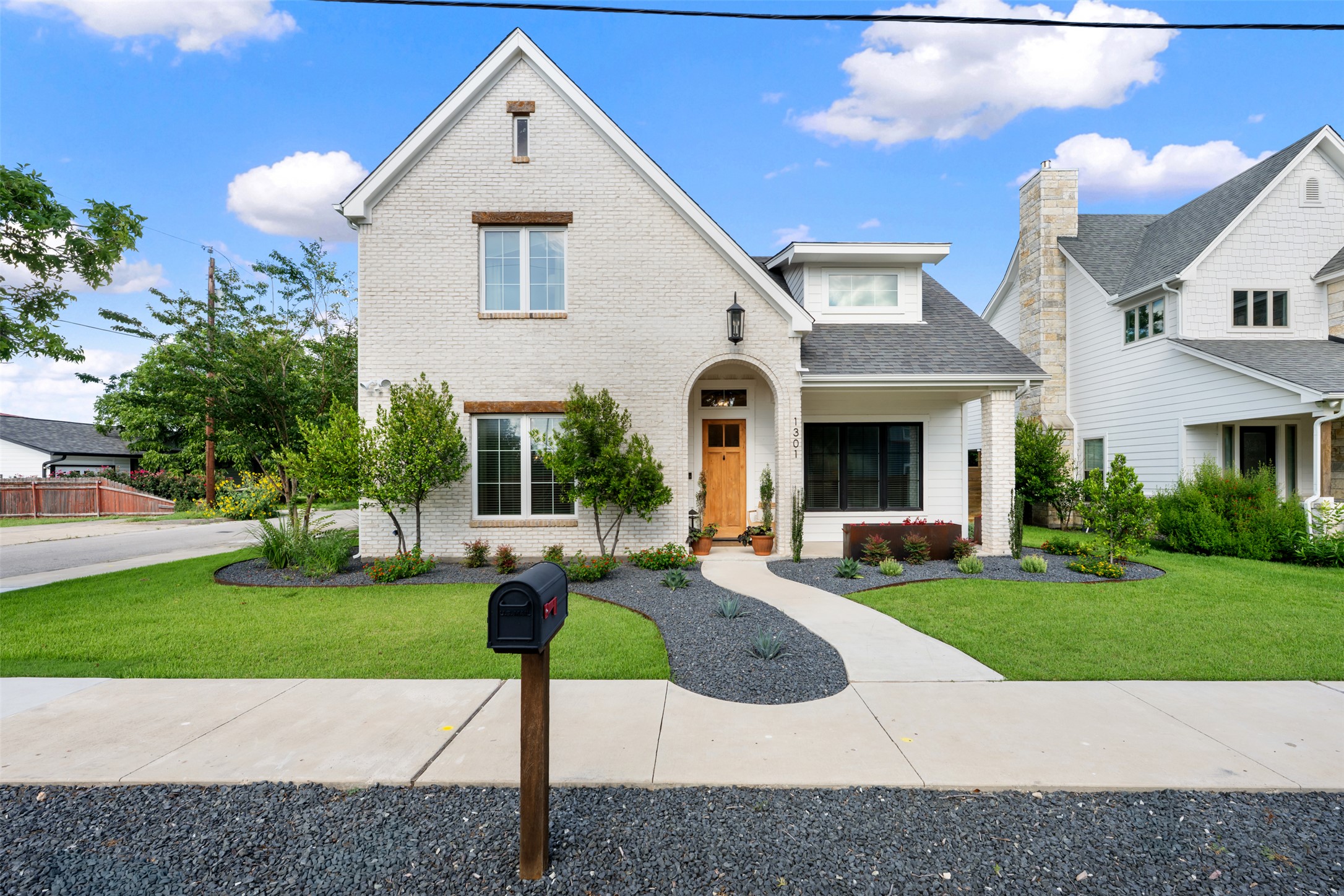 1301 West Street Georgetown, TX 78626 - Photo 1 of 40 Elegant white brick exterior with natural wood accents and thoughtful landscaping creates inviting curb appeal.