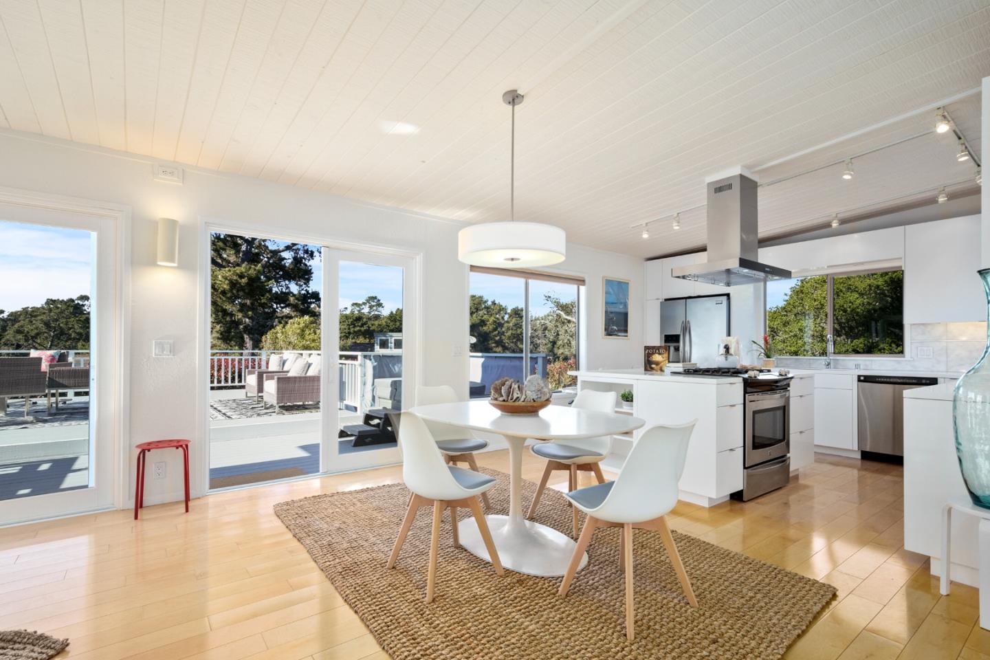 404 Arbolado Drive La Selva Beach, CA 95076 - Photo 6 of 36 a dining room with wooden floor a chandelier a glass table and windows