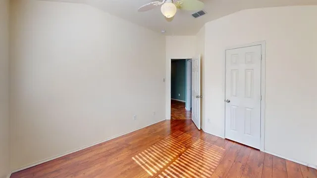 a view of an empty room with wooden floor