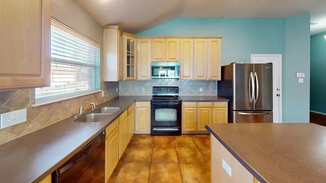 a kitchen with granite countertop a refrigerator and a sink