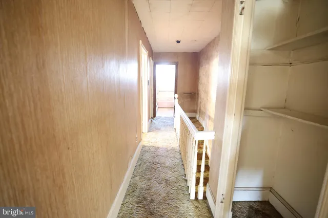 a view of a hallway with wooden floor and stairs