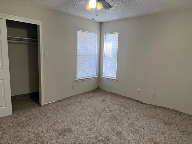 an empty room with closet and windows
