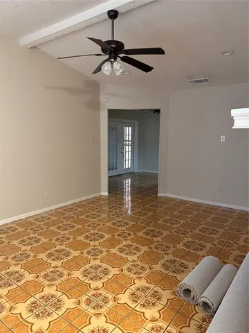 a view of a livingroom with a chandelier fan and wooden floor