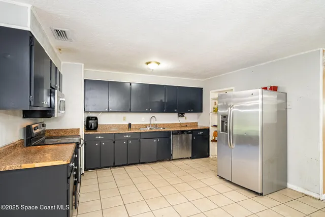 a kitchen with granite countertop a refrigerator and a sink