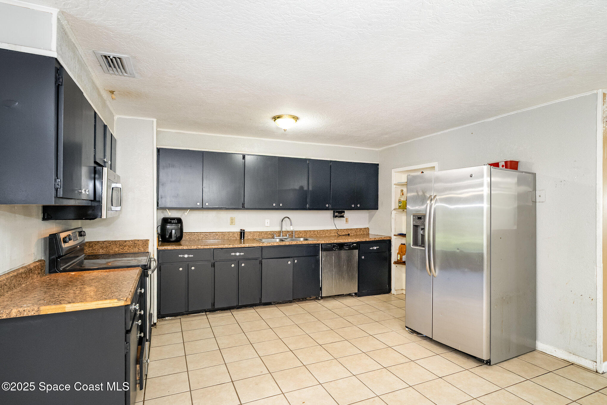 935 South Varr Avenue Rockledge, FL 32955 - Photo 12 of 29 a kitchen with granite countertop a refrigerator and a sink