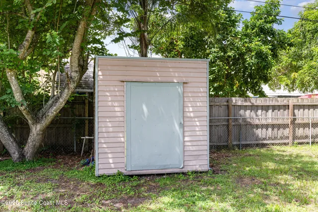 a view of a small house with a large tree and a yard