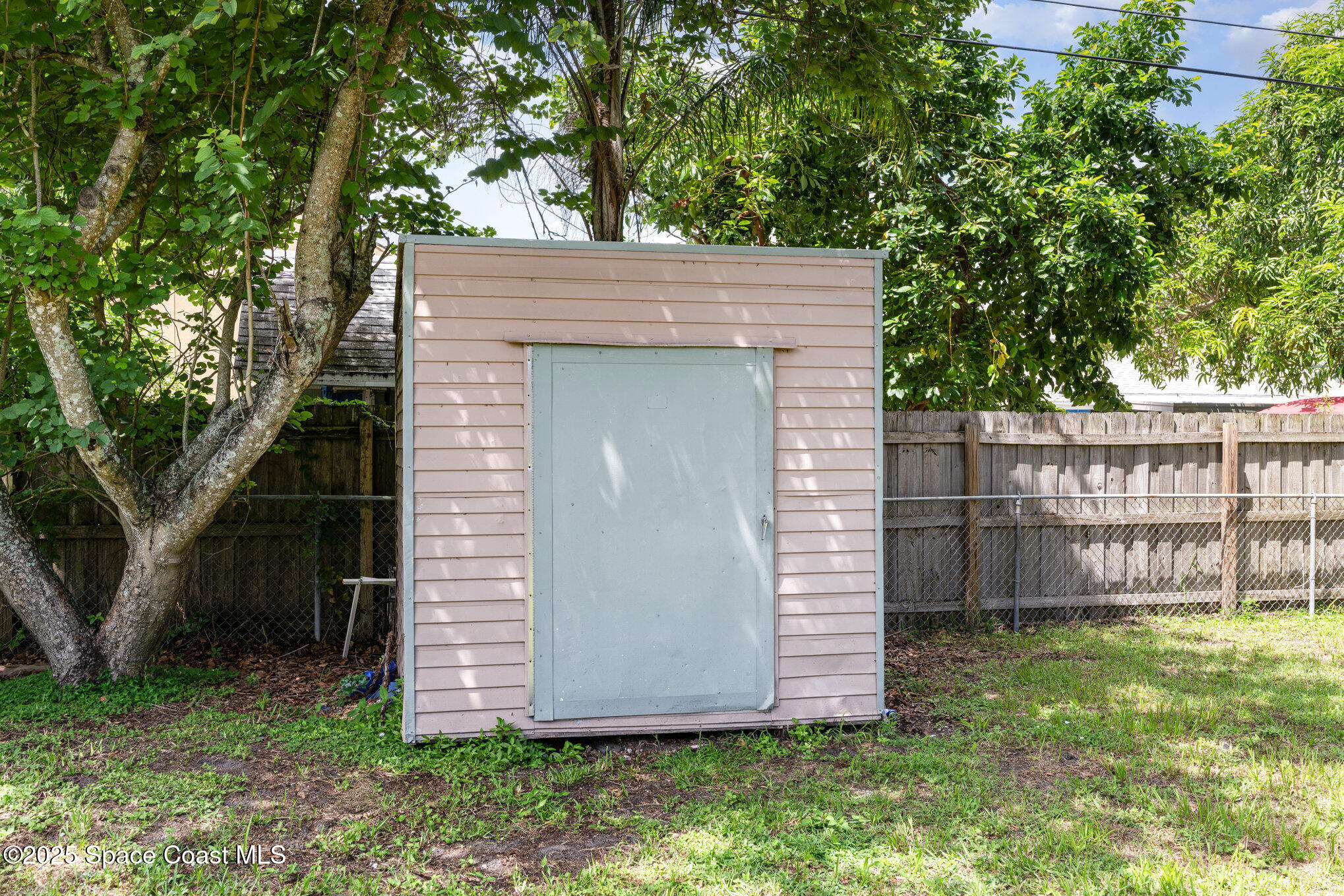935 South Varr Avenue Rockledge, FL 32955 - Photo 27 of 29 a view of a small house with a large tree and a yard