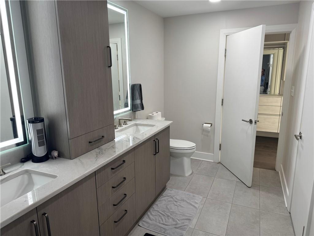306 Fourth Avenue, Unit 1602 Pittsburgh, PA 15222 - Photo 20 of 31 a bathroom with a double vanity sink a toilet and a mirror