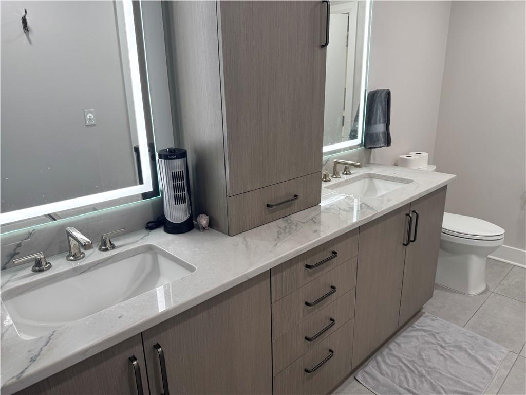 306 Fourth Avenue, Unit 1602 Pittsburgh, PA 15222 - Photo 21 of 31 a bathroom with a double vanity sink and a mirror