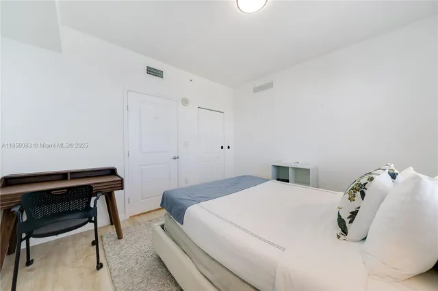 a bedroom with a bed and a desk