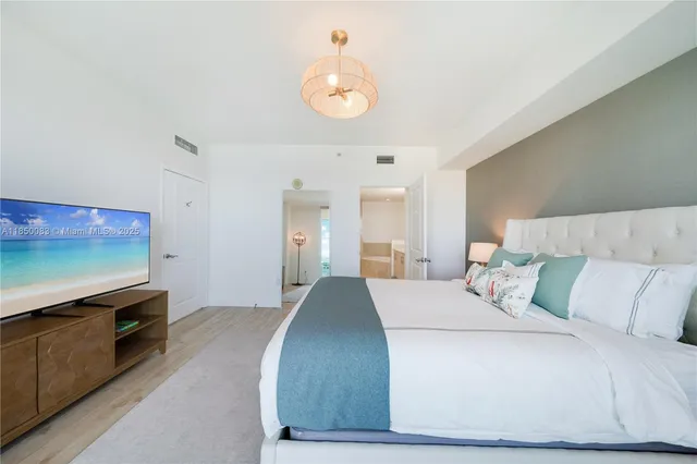 a bedroom with a bed and a flat screen tv