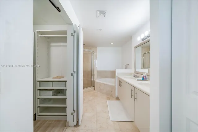 a bathroom with a double vanity sink a mirror and a bathtub