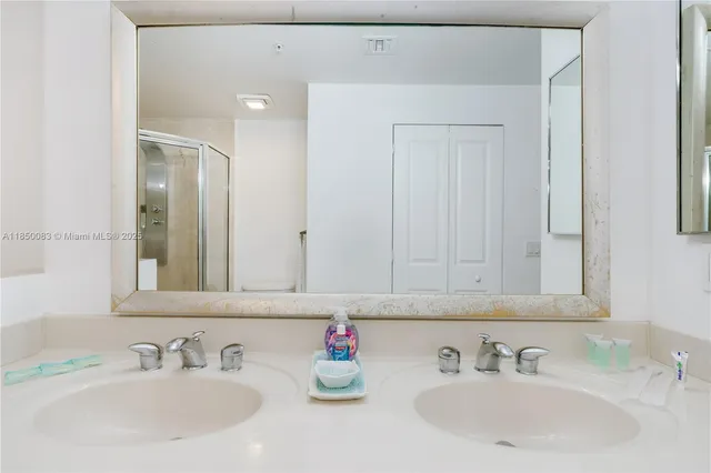 a bathroom with double vanity sinks and a mirror