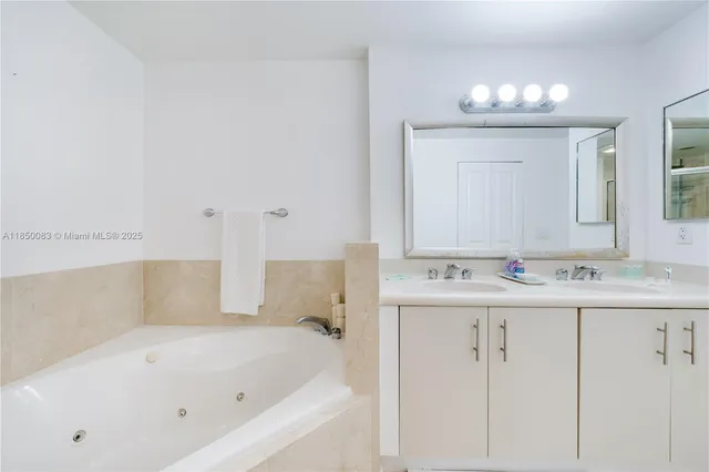 a bathroom with a bathtub a mirror a sink and vanity