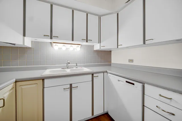 a kitchen with stainless steel appliances granite countertop white cabinets sink and dishwasher