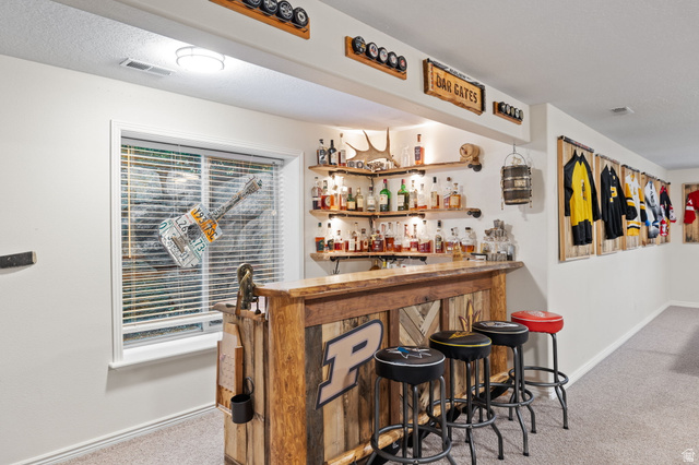 6208 West Bull River Road Highland, UT 84003 - Photo 48 of 90 Custom-built wood-finish bar featuring integrated shelving, under-shelf lighting, and a window with horizontal blinds