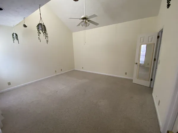an empty room with a window and a ceiling fan