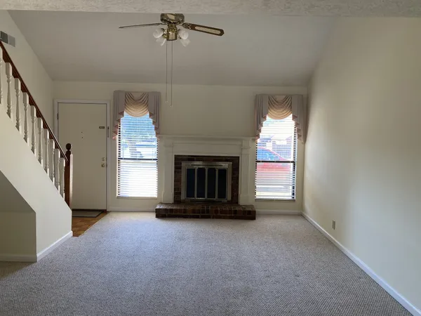 a view of an empty room with a fireplace and a window