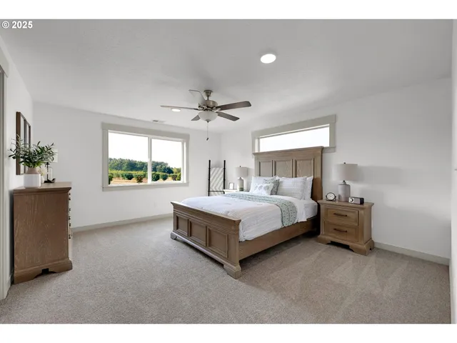 a spacious bedroom with a bed and a view of kitchen