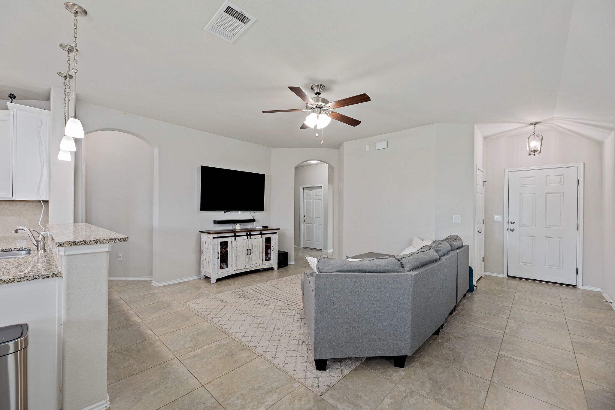 382 Limerick Road Buda, TX 78610 - Photo 3 of 20 Bright and inviting living area seamlessly transitions into a modern kitchen, ideal for entertaining.