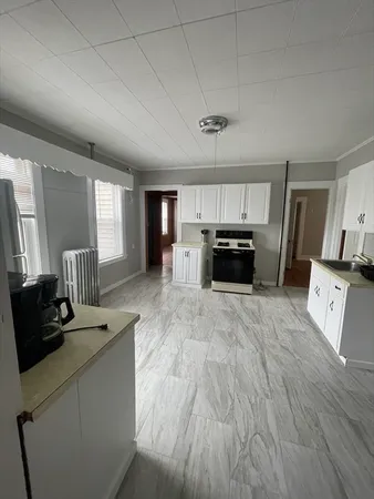 a kitchen with granite countertop a refrigerator and a stove top oven