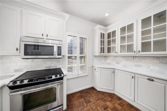 a kitchen with granite countertop cabinets stainless steel appliances and wooden floor