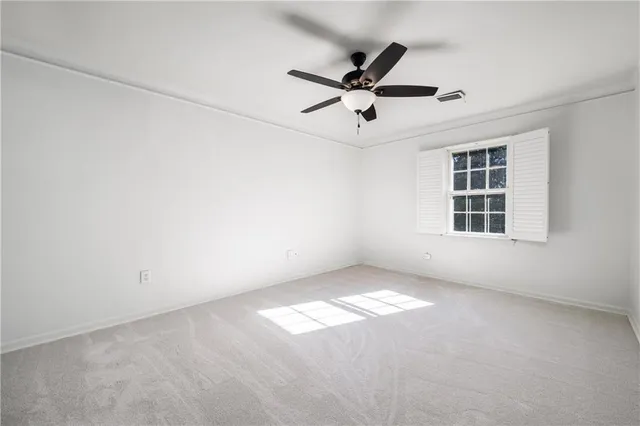 an empty room with a window and a fan
