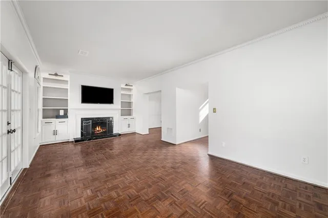 a view of an empty room with fire place and a window
