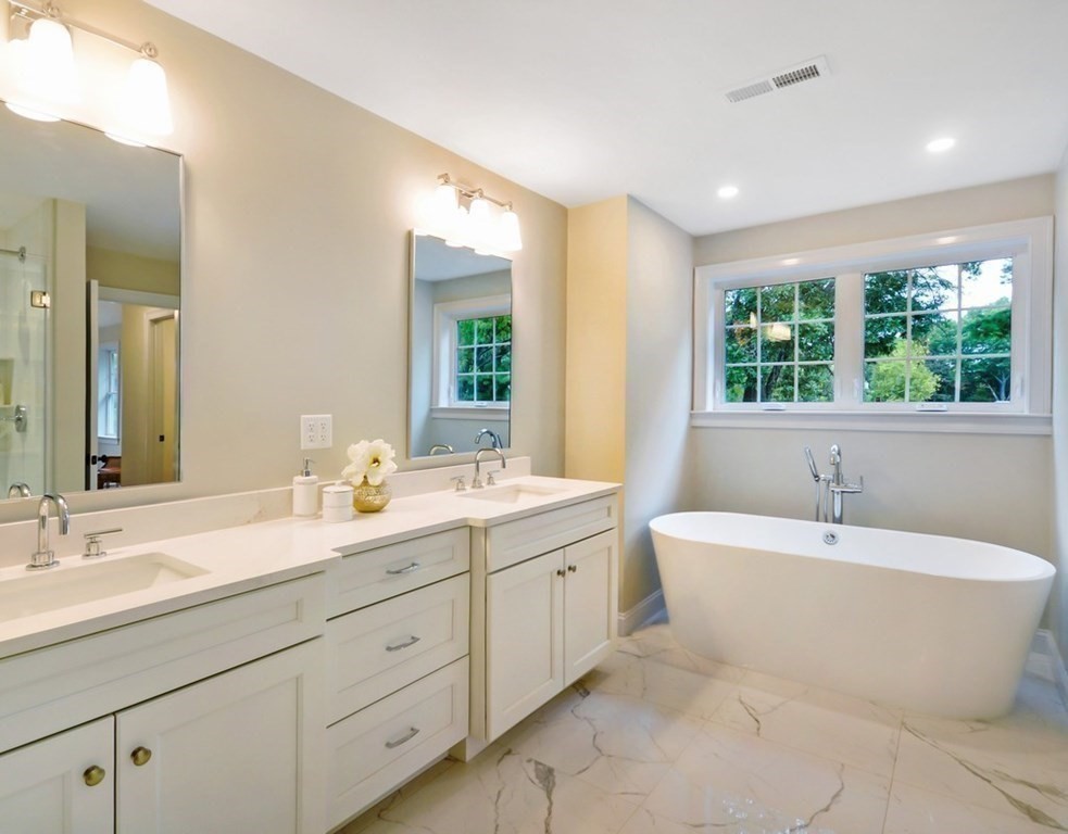 174 Wright Road Concord, MA 01742 - Photo 19 of 35 a spacious bathroom with a double vanity sink a large mirror and bathtub