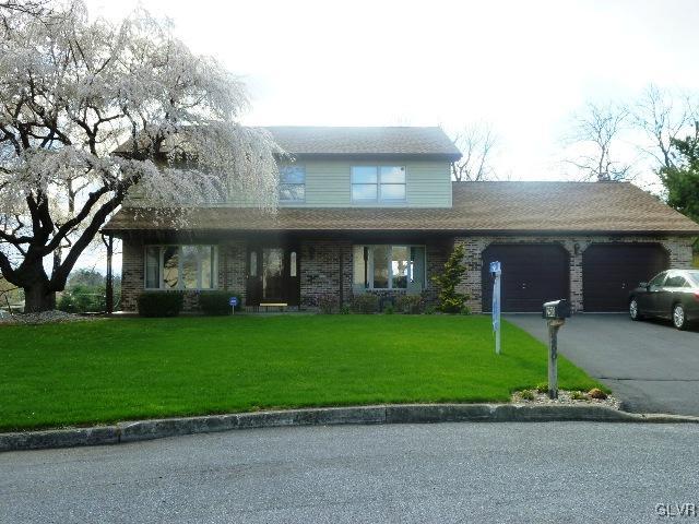 a front view of a house with a garden and yard