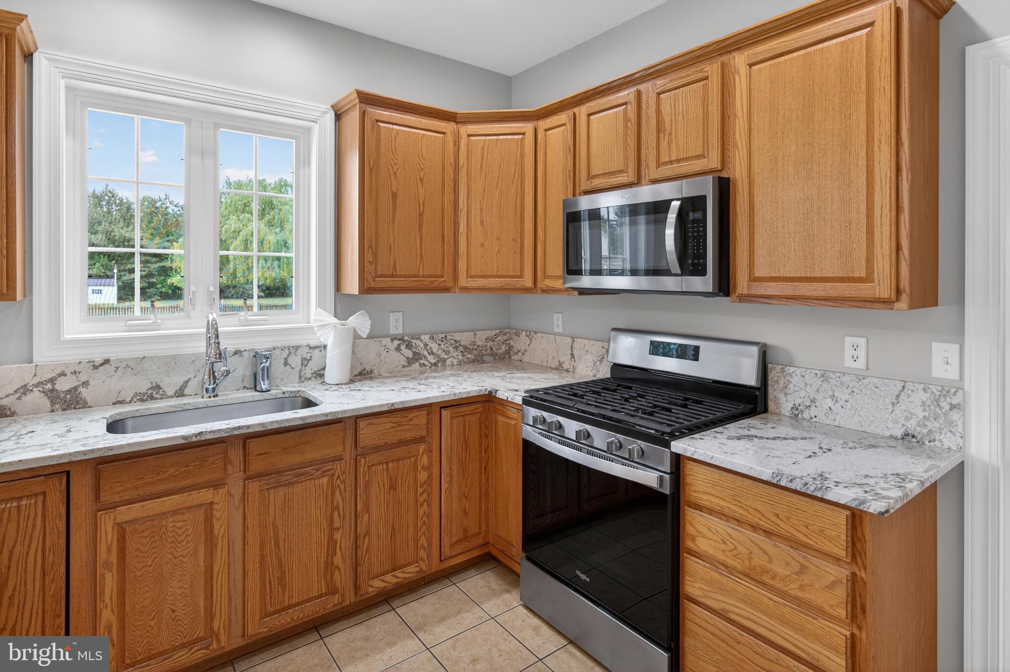 337 Roe Ingleside Road Centreville, MD 21617 - Photo 24 of 56 a kitchen with granite countertop cabinets stainless steel appliances a sink and a window