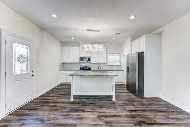 a view of kitchen with refrigerator microwave and wooden floor