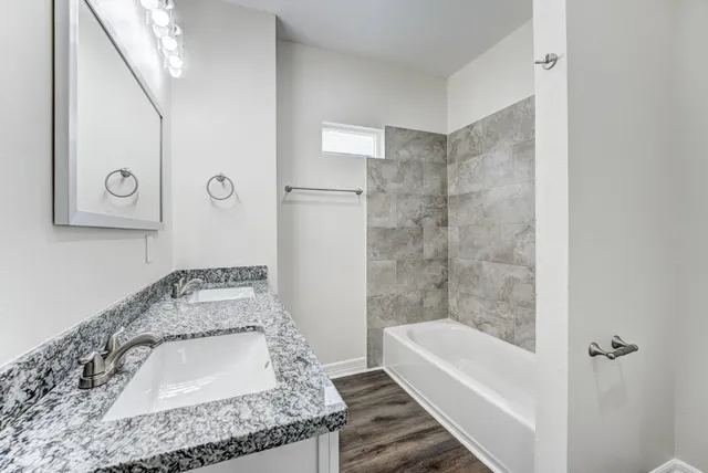 a bathroom with a granite countertop sink a toilet and bathtub