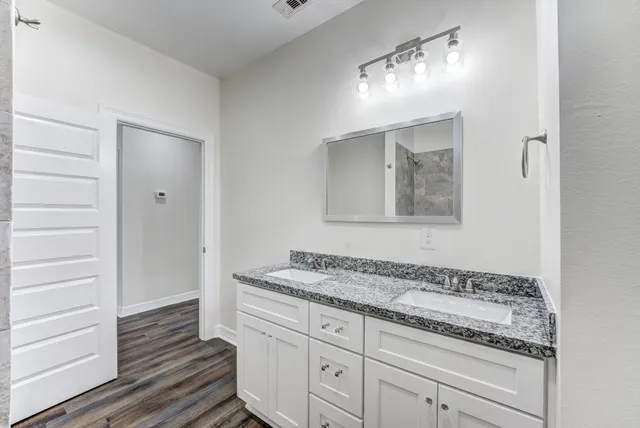 a bathroom with a granite countertop sink and a mirror